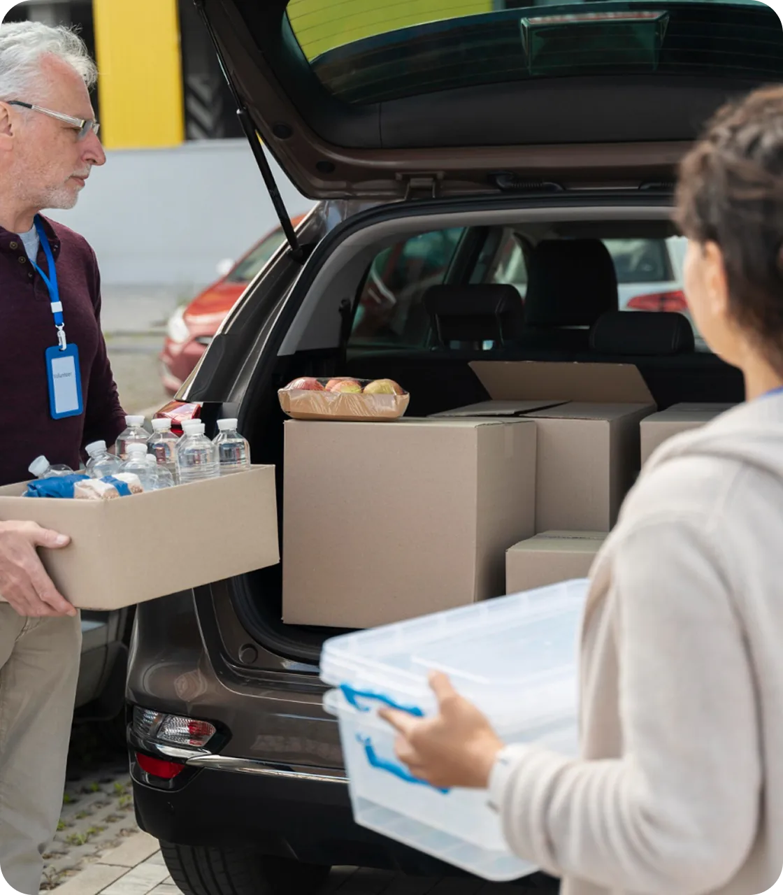 Volunteers loading supplies into a car trunk